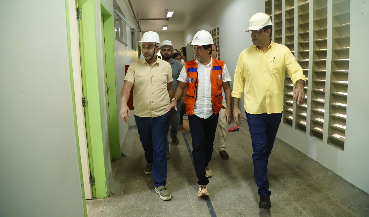 prefeito evandro e secretário andré caminham num corredor do hospital em reforma